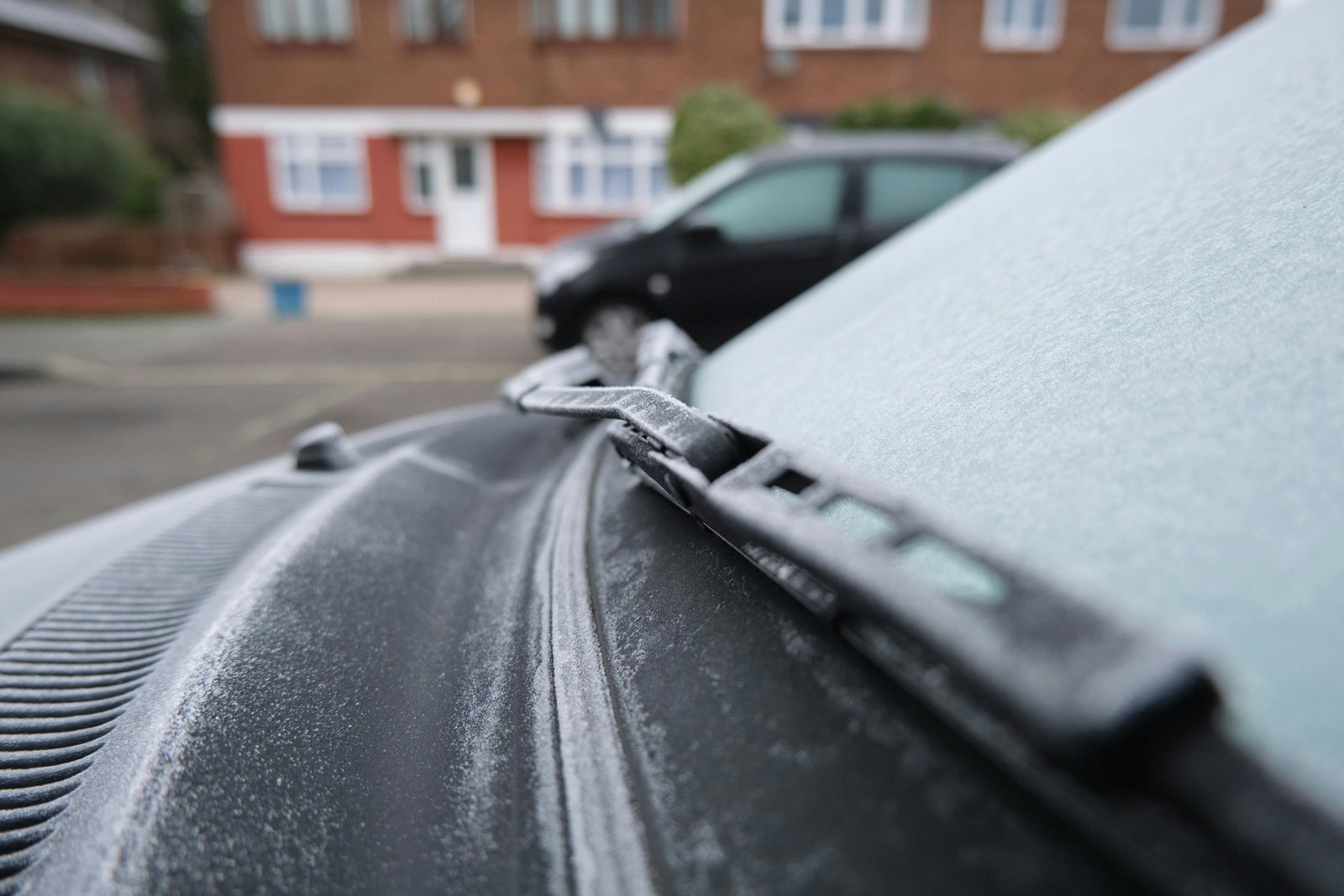 Hand reinigt eine Autoscheibe